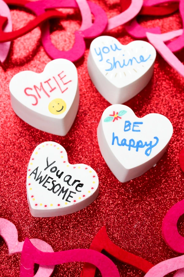 Create heart-shaped kindness rocks with this fun tutorial! It's so easy to make heart shaped rocks. They're perfect for Valentine's Day or any day! #kindnessrocks #Valentine #kidscrafts